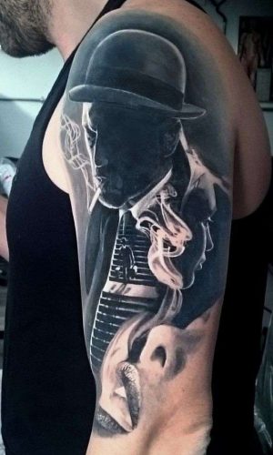 Black and grey realism half sleeve arm tattoo of Noir movies gangster with cigarette surrounded by the smoke from sensual woman lips by Alo Loco, London, UK. Cover up tattoo | tattoo rework cover up example | cover up tattoos
