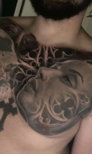 black and grey surrealistic chest tattoo of a skull and woman london artist
